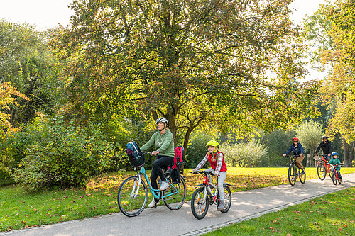 Familie radelt durch einen Park