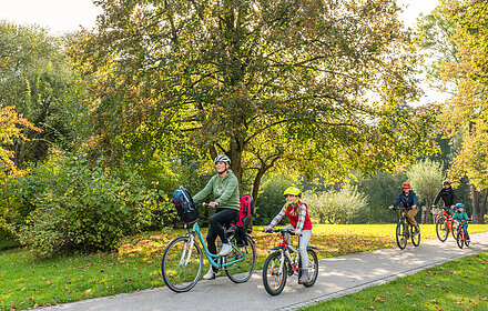 Familie radelt durch einen Park