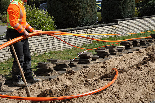 Auf einer Baustelle wird Glasfaserkabel verlegt