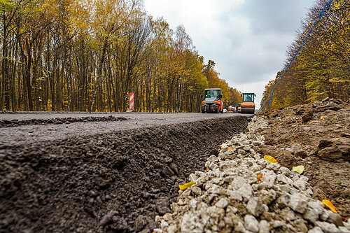 Close view on the road repairing. Roller working on the new road construction site