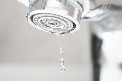 Wassertropfen, der vom Hahn fällt